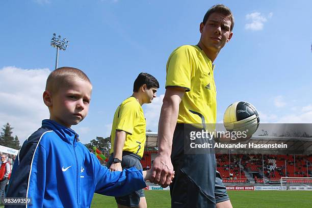 Referee Michael Kempter enters the field for the Third League match between SV Sandhausen and Holstein Kiel at Hardtwald Stadion on April 10, 2010 in...