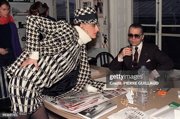 German Chanel's designer and art director of Chanel fashion house Karl Lagerfeld discusses with top model Inès de la Fressange March 13, 1987 the...