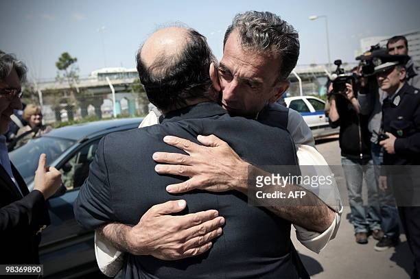Greek national Athanassios Lerounis hugs Greek Ambassador in Islamabad Petros Mavroeedis after his arrival at Athens International Airport on April...