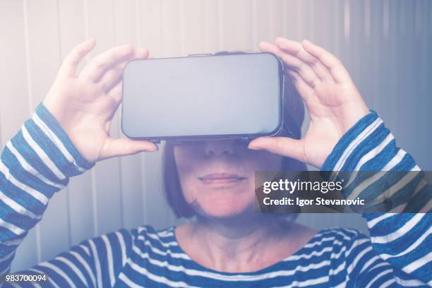 woman watching 360 video with virtual reality headset - 360 video stock pictures, royalty-free photos & images