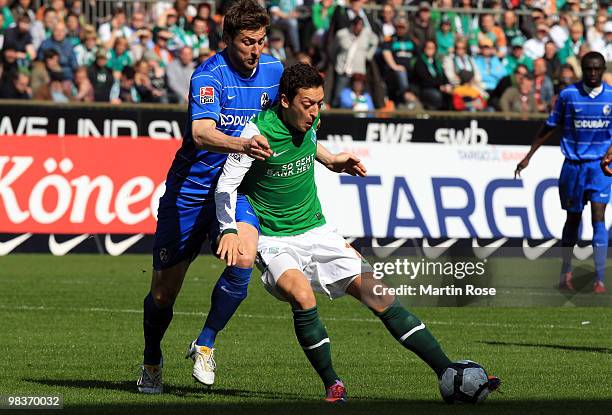 Mesut Oezil of Bremen and Heiko Butscher of Freiburg compete for the ball during the Bundesliga match between Werder Bremen and SC Freiburg at the...