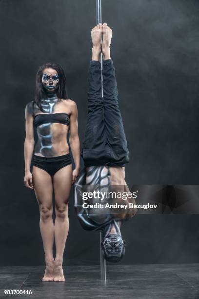 posing of pole dance couple in dark studio - pole dance stockfoto's en -beelden