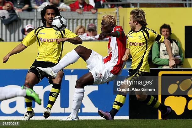 Aristide Bance of Mainz is challenged by Patrick Owomoyela and Jakub Blaszczykowski of Dortmund during the Bundesliga match between FSV Mainz 05 and...