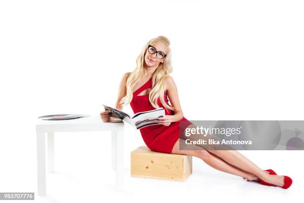 woman in red dress holding a magazine - antonova stock pictures, royalty-free photos & images