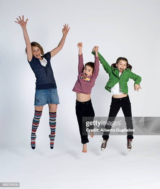 three kids jump in the air.  - newfriendship stock pictures, royalty-free photos & images