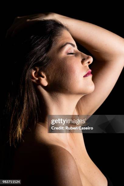 beautiful girl touching her hair with eyes closed - caseiro stockfoto's en -beelden