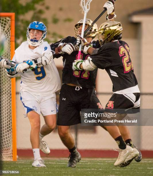 Falmouth attack Tom Fitzgerald passes the ball , opposed by Thornton Academys Cameron Houde and Anthony Bracamonte during varsity lacrosse action in...