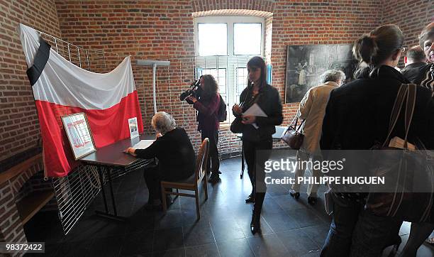 The president of the House Polonia in France Françoise Aghamalian-Konieczna signs a memory book at the Flers Castle in Villeneuve-d'Ascq, northern...