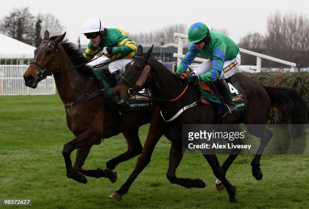 Don't Push It ridden by A.P McCoy clears the last fence and races for the finish line alongside Black Apalachi ridden by Denis O'Regan on their way...