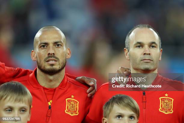 David Silva of Spain and Andres Iniesta of Spain look on during the national anthems prior to the 2018 FIFA World Cup Russia group B match between...