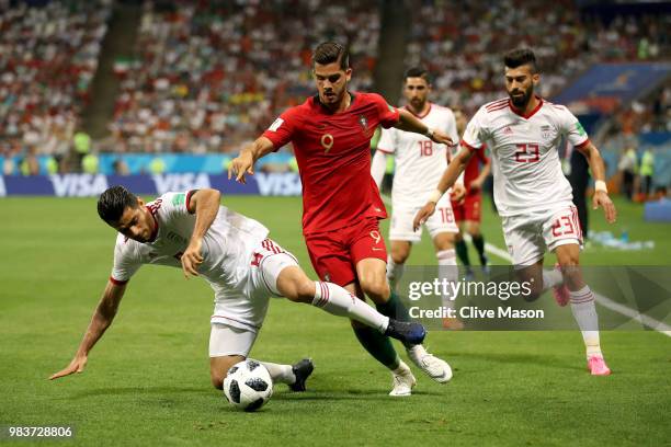 Andre Silva of Portugal is challenged by Ramin Rezaeian and Morteza Pouraliganji of Iran during the 2018 FIFA World Cup Russia group B match between...