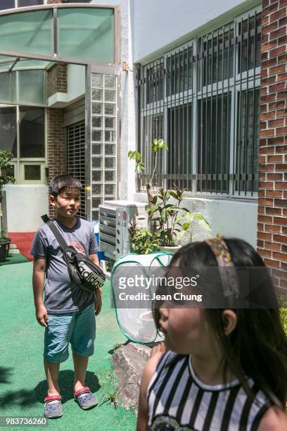 Children stand in front of the barred window of Hyoseong Elementary School, which used to be a POW camp during the Korean War, on June 24, 2018 in...