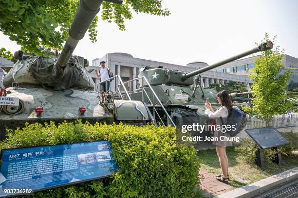 South Korean youths take a snapshot with the tanks which were used during the Korean War at the War Memorial of Korea, on June 24, 2018 in SEOUL,...