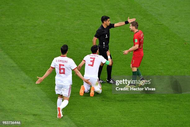 Adrien Silva of Portugal and Ehsan Haji Safi of Iran argue with Referee Enrique Caceres during the 2018 FIFA World Cup Russia group B match between...