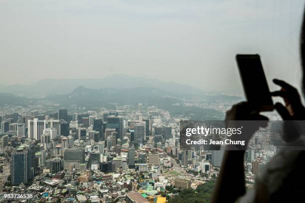 Tourist takes a picture of the aerial view of downtown Seoul, on Seoul N Tower, on June 25, 2018 in SEOUL, South Korea. Over 66,000 South Koreans...