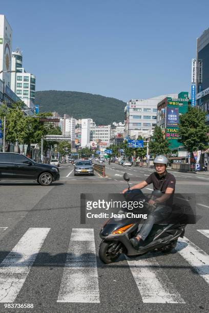Man rides a motorbike on the main road near Jagalchi Seafood Market on June 24, 2018 in Busan, South Korea. Over 66,000 South Koreans have been...