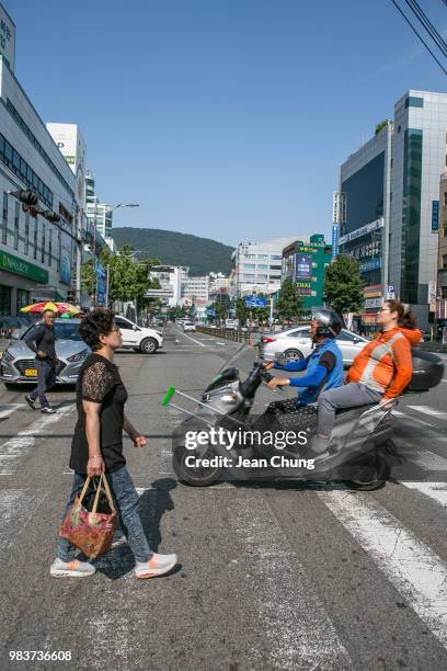 Pedestrians cross the main boulevard near Jagalchi Seafood Market on June 24, 2018 in BUSAN, South Korea. Over 66,000 South Koreans have been...