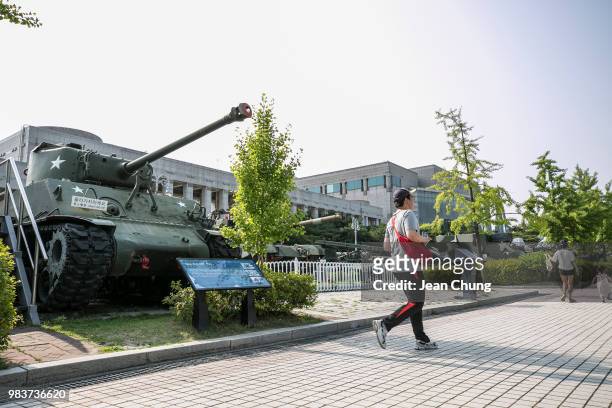 Man runs in front of the tanks which were used during the Korean War at the War Memorial of Korea, on June 24, 2018 in SEOUL, South Korea. Over...