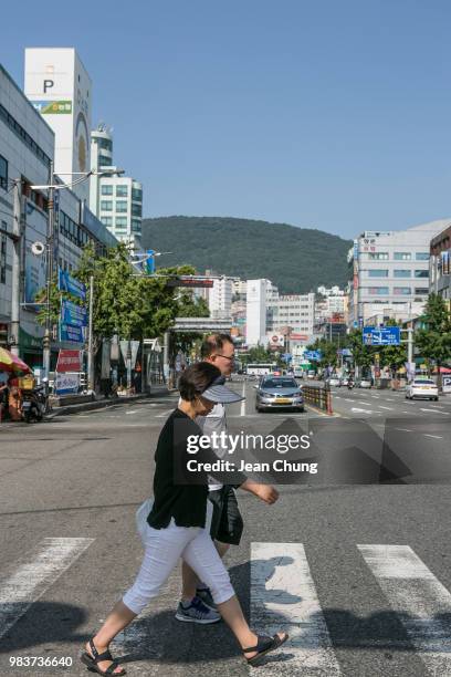 Pedestrians walk on the main road near Jagalchi Seafood Market on June 24, 2018 in Busan, South Korea. Over 66,000 South Koreans have been separated...