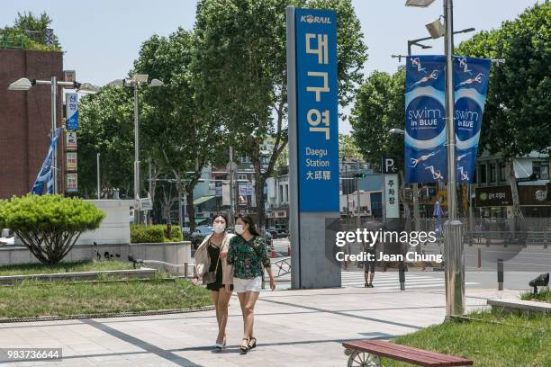 Women walk next to the sign post that says "Daegu Station" on June 24, 2018 in DAEGU, South Korea. Over 66,000 South Koreans have been separated from...