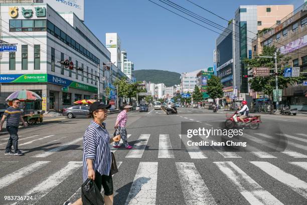 Pedestrians cross the main boulevard near Jagalchi Seafood Market on June 24, 2018 in BUSAN, South Korea. Over 66,000 South Koreans have been...