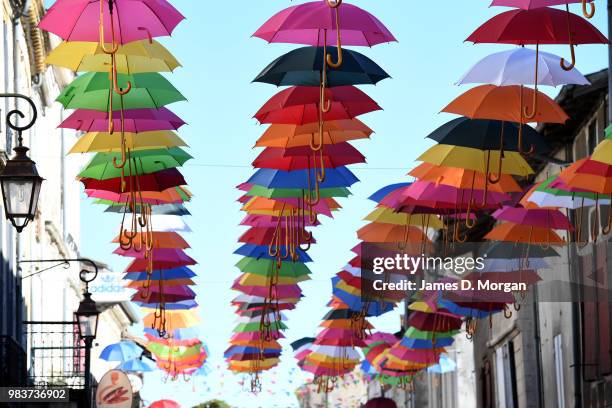 Colourful umbrellas hang above the main street as part of a summer art installation to brighten the town for locals and visitors on June 25, 2018 in...