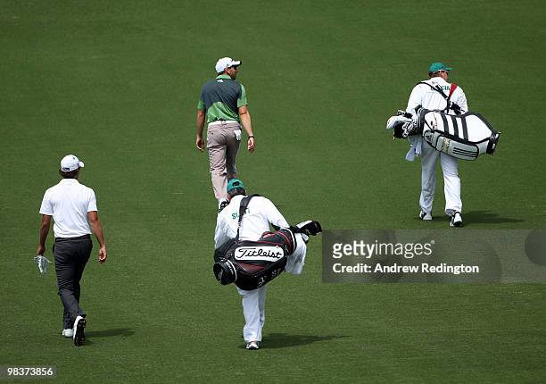 Adam Scott of Australia walks with Sergio Garcia of Spain and their caddies down the first fairway during the third round of the 2010 Masters...