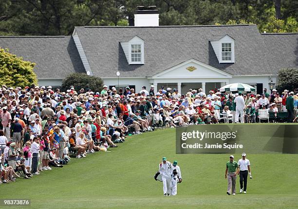 Adam Scott of Australia walks with Sergio Garcia of Spain and their caddies down the first fairway during the third round of the 2010 Masters...