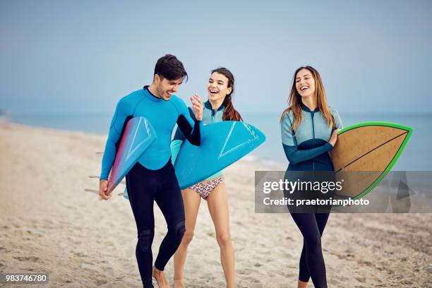 surfer am strand gehen und spaß machen - neopren stock-fotos und bilder