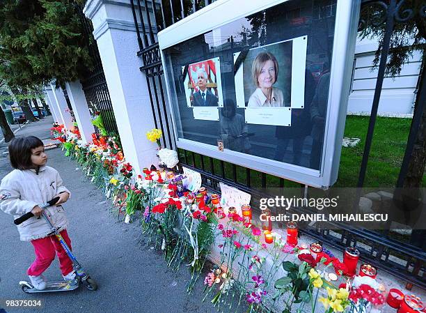 Young girl looks at the portraits of Polish President Lech Kaczynski and his wife Maria Kaczynska, in front of the Polish embassy in Bucharest on...