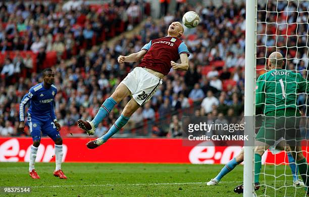 Aston Villa's Welsh defender James Collins narrowly avoids heading the ball into his own net during the FA Cup semi-final football match against...