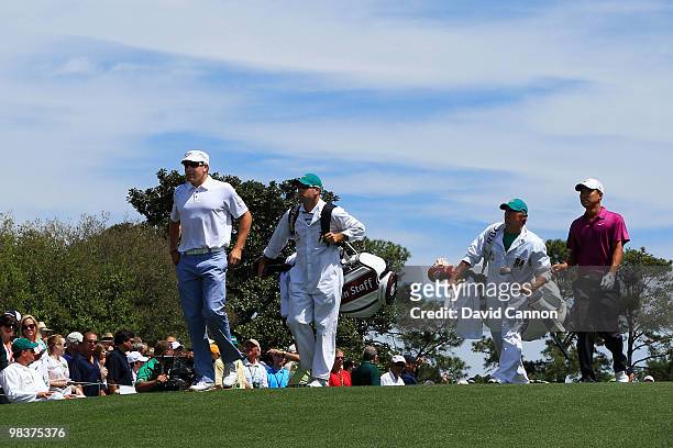 Ricky Barnes and Anthony Kim walk off the first tee with their caddies Andy Barnes and Brodie Flanders during the third round of the 2010 Masters...
