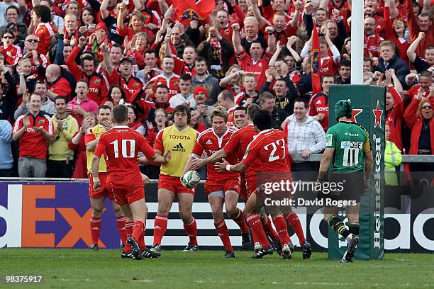 Jean de Villiers of Munster is congratulated by team mates after scoring a try during the Heineken Cup quarter final match between Munster and...