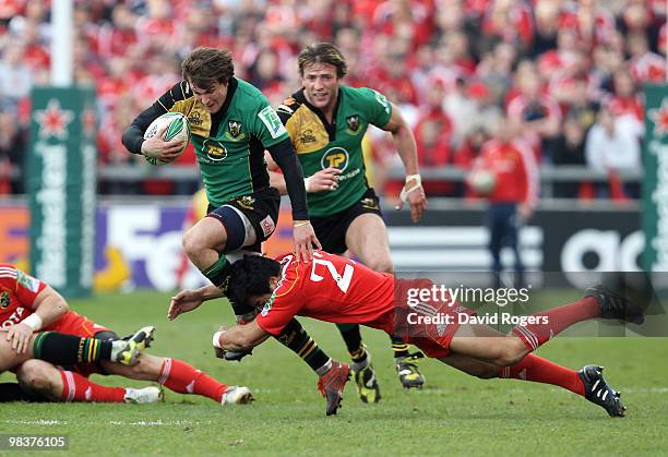 Lee Dickson of Northampton is tackled by Lifeimi Mafi during the Heineken Cup quarter final match between Munster and Northampton Saints at Thomond...