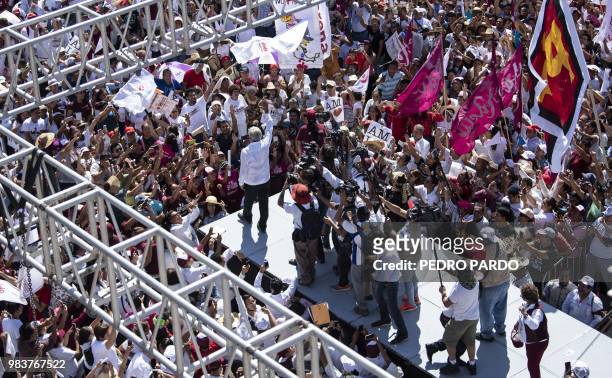 Members of the press stand behind Mexico's presidential candidate for the MORENA party, Andres Manuel Lopez Obrador, as he greet supporters during a...