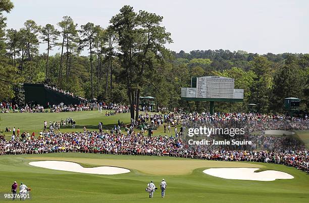 The group of Anthony Kim and Ricky Barnes walk with their caddies to the second green during the third round of the 2010 Masters Tournament at...