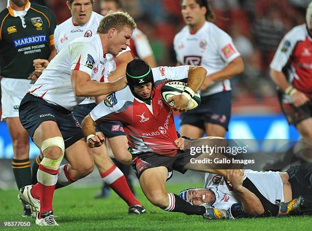 Herkie Kruger of the Lions tackled by Daniel Braid and Ben Daley of the Reds during the Super 14 match between Lions and Reds from Coca Cola Park...