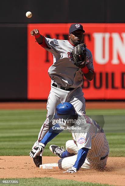 Cristian Guzman of the Washington Nationals turns a double play as David Wright of the New York Mets slides during their game on April 10, 2010 at...