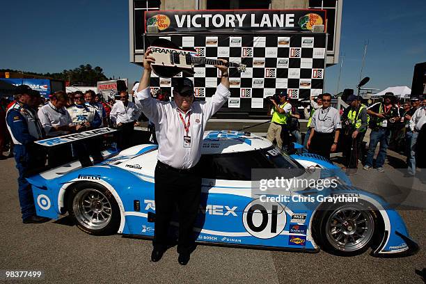 Team owner Chip Ganassi celebrates with the winner's trophy after his TELMEX Chip Ganassi Racing with Felix Sabates Lexus Riley driven by Memo Rojas...