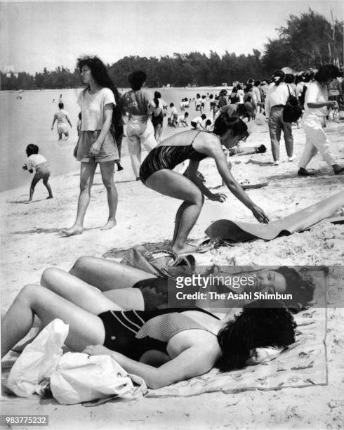 People enjoy sunbathing at Sukuji Beach on March 21, 1987 in Ishigaki, Okinawa, Japan.
