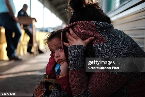 Honduran child and her mother, fleeing poverty and violence in their home country, waits along the border bridge after being denied entry from Mexico...