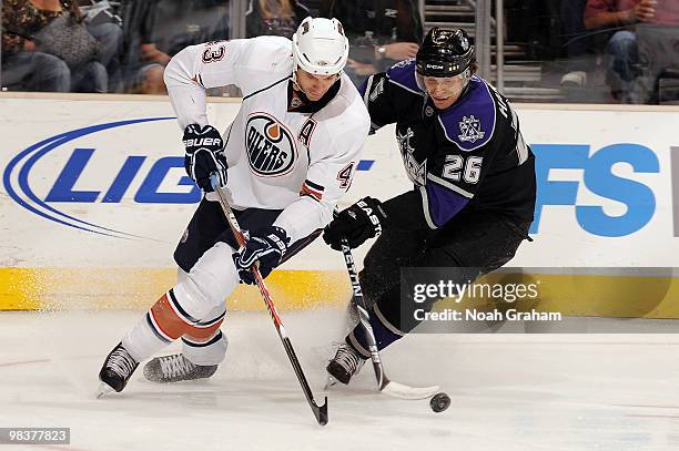 Jason Strudwick of the Edmonton Oilers reaches for the puck against Michal Handzus of the Los Angeles Kings on April 10, 2010 at Staples Center in...