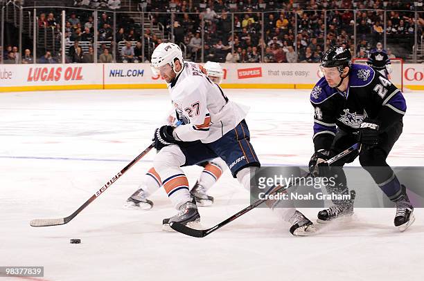 Dustin Penner of the Edmonton Oilers skates with the puck against Alexander Frolov of the Los Angeles Kings on April 10, 2010 at Staples Center in...