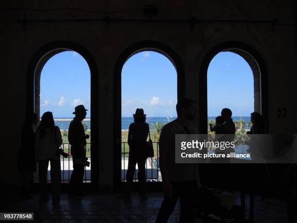 June 2018, Italy, Palermo: Visitors of the Manifesta 12 stand in front of windows of the Palazzo Forcella De Seta in Palermo. The 12th edition of the...