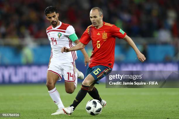 Andres Iniesta of Spain runs with the ball under pressure from Mbark Boussoufa of Morocco during the 2018 FIFA World Cup Russia group B match between...