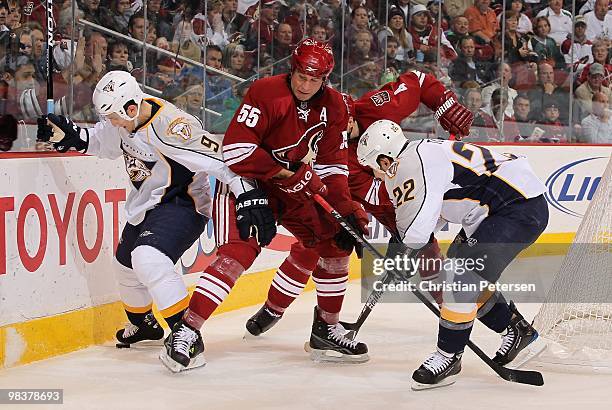 Marcel Goc of the Nashville Predators attempts to control the puck under pressure from Ed Jovanovski of the Phoenix Coyotes during the NHL game at...