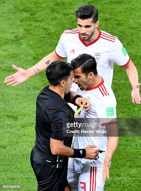 Referee Enrique Caceres books Ehsan Haji Safi of Iran as Iran players complain about his decision to award Portugal a penalty during the 2018 FIFA...