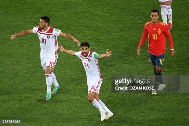 Morocco's midfielder Mbarek Boussoufa and Morocco's midfielder Younes Belhanda appeal for a handball by Spain's defender Gerard Pique past Spain's...