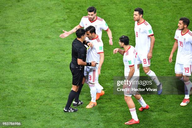 Referee Enrique Caceres books Ehsan Haji Safi of Iran as Iran players complain about his decision to award Portugal a penalty during the 2018 FIFA...