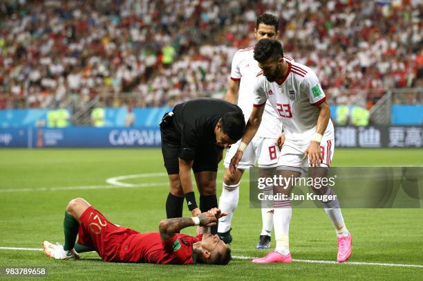Referee Enrique Caceres anf Ramin Rezaeian of Iran check conditions of Ricardo Quaresma of Portugal during the 2018 FIFA World Cup Russia group B...